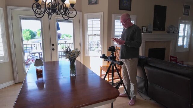Senior man setting up a camera slider with a smartphone application