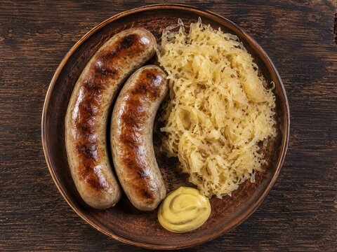 Zwei goldbraun gebratene fr&auml;nkische Bratw&uuml;rste mit Sauerkraut und cremigem Senf aus der Vogelperspektive &ndash; traditionell deutsches Wirtshausgericht, herzhaft serviert.