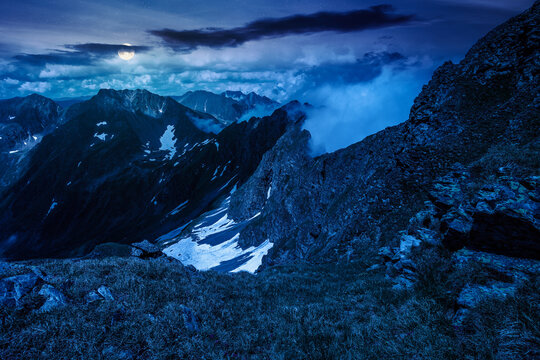 romania mountain landscape in summer at night. full moon over travel background of alpine scenery in fagaras mountain ridge. european summer outdoor adventures. mysterious fantasy