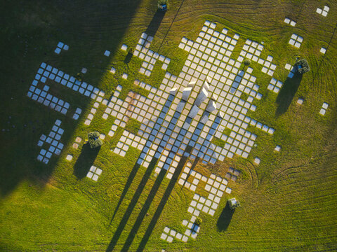 Maia, Portugal - 25 June 2026: Aerial view of Jardim das Piramides with its geometric stone paving and pyramid structures set in a green park during the golden hour.