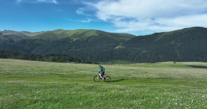 Aerial footage of woman riding mountain bike on beautiful forest mountain trail
