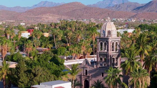 Aerial views show the historic Loreto Mission church at sunrise in Baja California Sur, highlighting the beauty of the area.