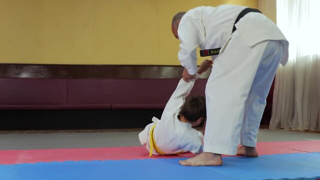 The coach trains the athlete to perform throws and falls