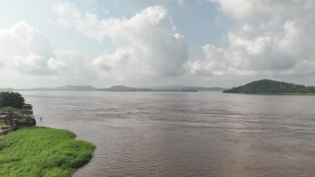 Congo River, DR Congo - forested hills and riverside stilt houses, aerial drone view