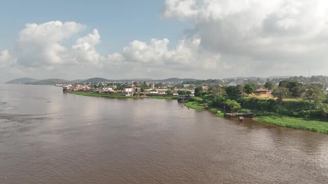 Congo River, DR Congo - a riverside town with a distant barge, aerial drone view