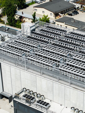 Riga, Latvia - 24 June 2026: Aerial view of the EU North Riga data center rooftop featuring rows of industrial cooling fans and ventilation units.