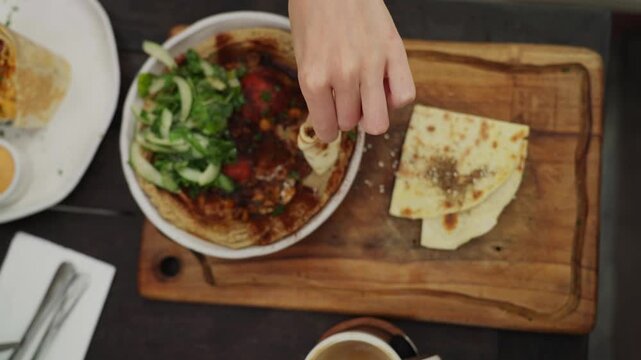 Woman eating delicious hummus with pita bread