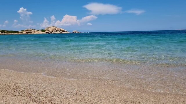 Beautiful turquoise sea and golden sand on La Licciola beach, in a sunny summer day, in Sardinia, Italy. Selective focus, blurred background