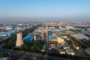 Obraz premium Industrial complex featuring cooling tower smokestacks factory buildings and infrastructure under clear sky