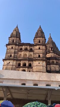 Ancient Indian Temple Towers with Birds Flying Under Blue Sky