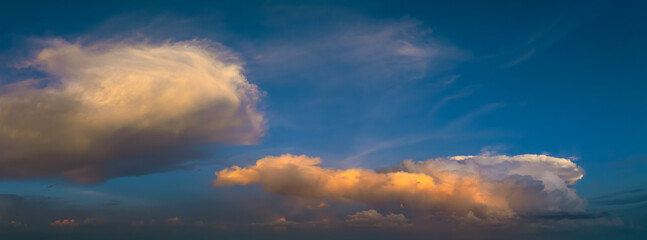Obraz premium Dramatic sunset sky covered with colorful yellow clouds. Panoramic skyscape