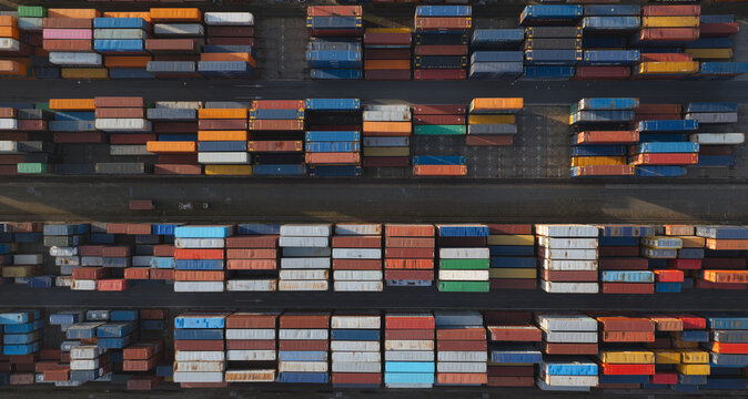 Portugal - 25 June 2026: Aerial view of shipping containers stacked in a container terminal at a port, with rows of colorful metal boxes arranged in a grid pattern.