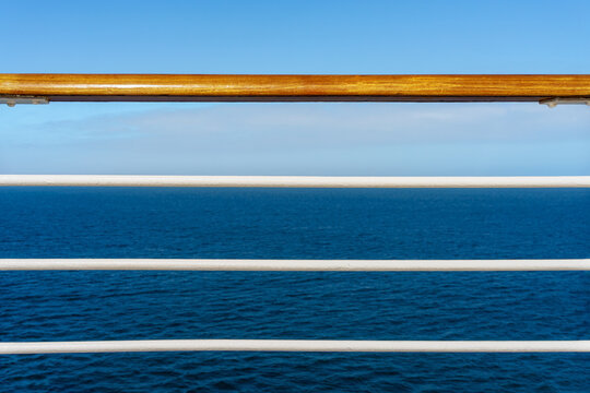 Cruise ship deck railing and a ocean view with blue sky