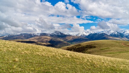 Fototapeta premium Dzhily-Su, Russia - June 4, 2026: View of the Caucasus Mountains along the road to Dzhily-Su, showing mountain peaks, valleys, winding road, open landscapes, and scenic natural surroundings.