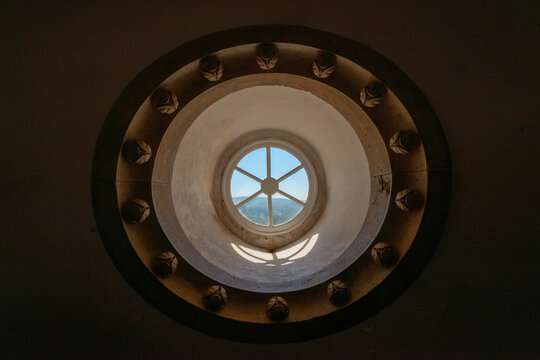 Circular stone tower window casting light inside historic fortress interior.