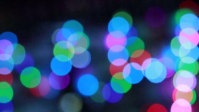Vibrant multi-colored bokeh lights background with soft blurred circular lens flare effects for festive decorative abstract graphic design elements