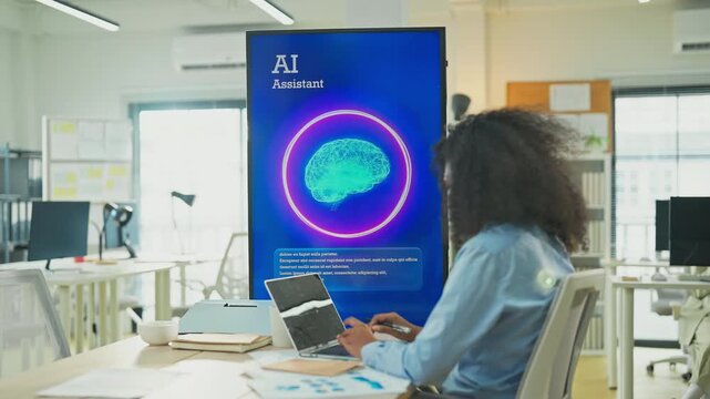 African American female marketer using laptop and AI consultant on multiple screens to restructure business and marketing strategy in modern open office, Black professional digital transformation conc