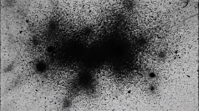 Abstract black ink splatter on textured wooden surface with random pattern and varied size