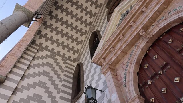 Detailed low angle view of the grand wooden entrance portal and tiled wall pattern of the Cathedral Basilica in Mazatlan Mexico