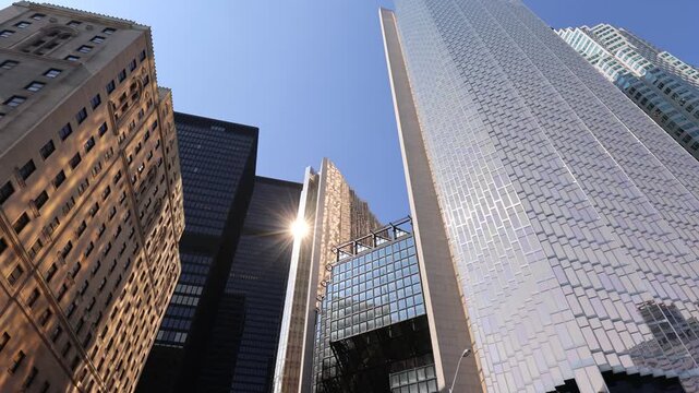 Looking up at the iconicglass office towers of the financial district against a clear blue sky in downtown Toronto Canada