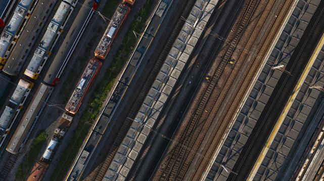 Portugal - 24 June 2026: Aerial view of a busy train terminal with multiple passenger and freight trains on parallel tracks, showcasing industrial infrastructure and rail patterns.