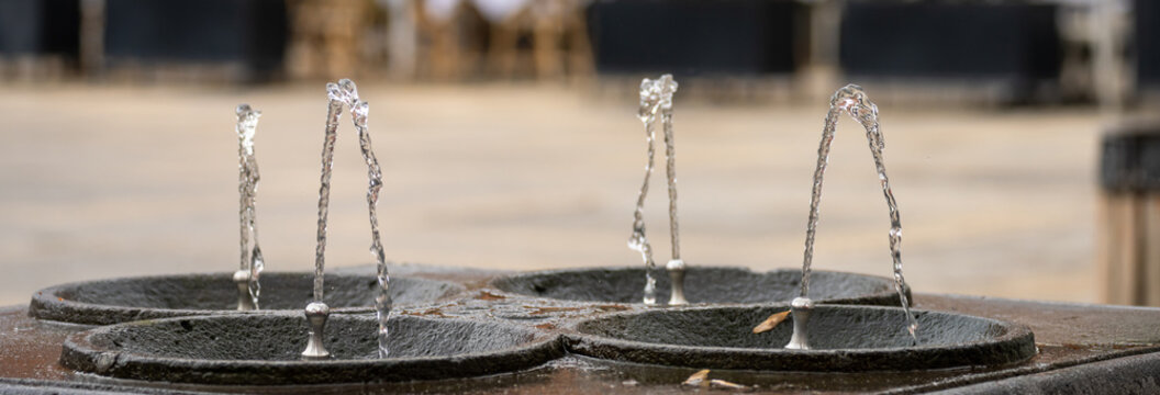 Public drinking water fountain providing clean potable water, symbolizing accessibility, hydration, urban infrastructure, and public health in a city environment.