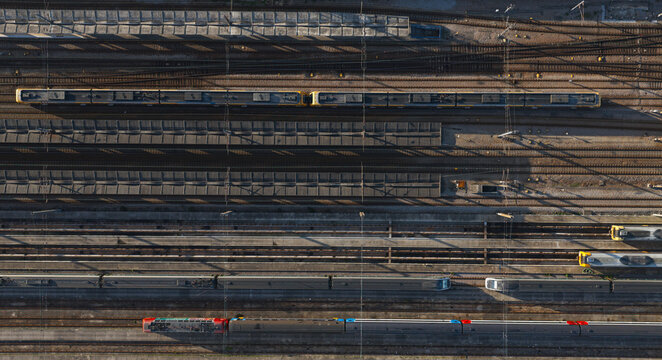 Portugal - 24 June 2026: Aerial view of a busy train terminal with multiple passenger trains parked on parallel tracks, showcasing complex railway infrastructure.