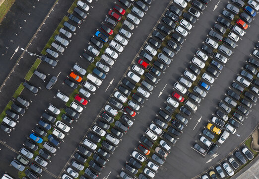 Portugal - 24 June 2026: Aerial view of a parking lot filled with cars of people commuting to work, showing organized rows and painted parking spaces.