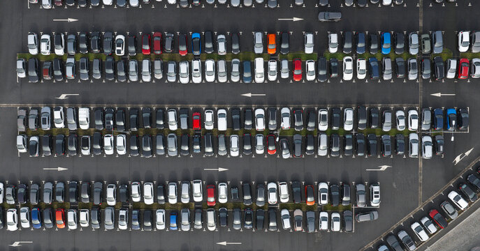 Portugal - 24 June 2026: Aerial view of a large parking lot filled with numerous cars parked in orderly rows with white painted directional arrows on the asphalt.