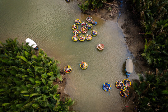 Aerial view of traditional round basket boats navigating the river in the Coconut village, surrounded by lush palm trees in Hoi An Dong, Da Nang, Vietnam.