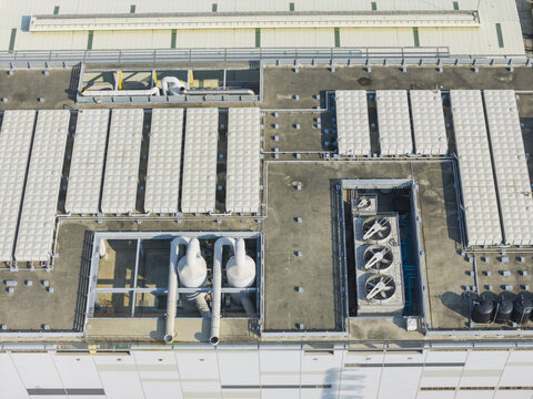 Aerial view of industrial rooftop featuring multiple HVAC cooling fans, ventilation pipes, and large rectangular vents on a flat concrete surface in Taiwan.