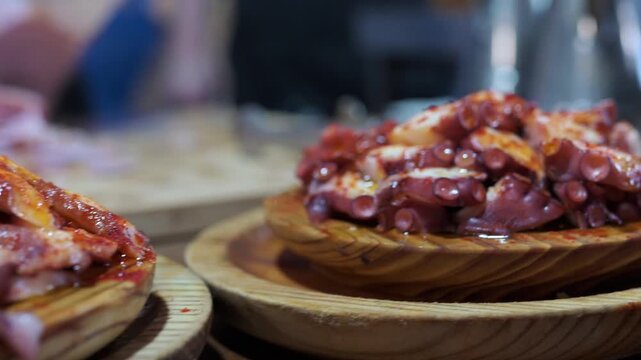 Traditional spanish pulpo a la gallega tapa served on wooden plates. Freshly boiled octopus seasoned with paprika and olive oil