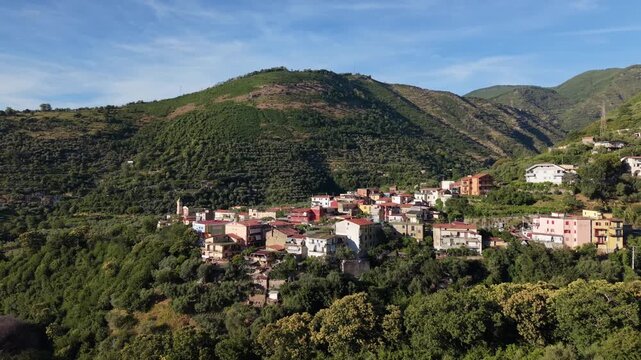 Aerial view of Aurano village with Parrocchia Sant'Agnello Abate church bell tower and terracotta rooftops nestled between green mountain slopes in Gragnano, Naples, Italy