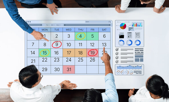 Business professionals collaborating on a digital calendar interface with data charts and visualizations for effective planning and decision-making. Bitwise.