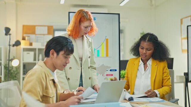 Diverse multiracial team presenting AI-powered marketing restructuring strategy on screen in modern open office, analysts reviewing business documents and data for corporate transformation concept