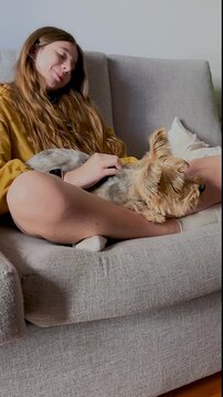 Cute little girl cuddling her yorkie puppy at home.4K vertical recording.Moments of calm and happiness. Puppy lovers.Teenager enjoying cute moments with her puppy at home.Ideal format for social media