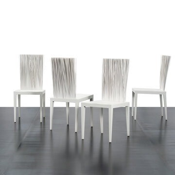 group of four designer chairs with a special flexible backrest made with white PVC stems.