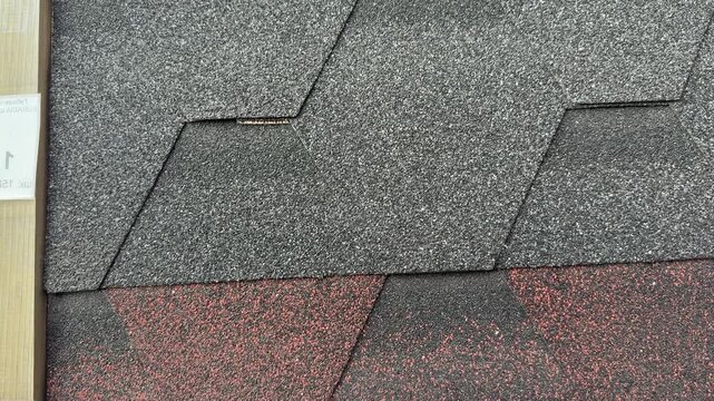 Closeup flexible roof tiles textured sample. Interlocking hexagonal shingle pattern with coarse mineral granules and two tone grey