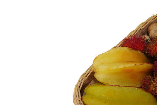 bowl of assorted tropical fruits including rambutan langsat and starfruit. raw healthy organic food