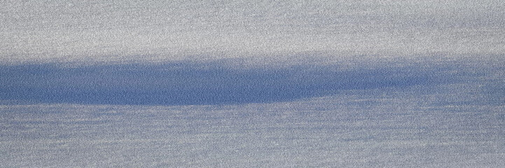 A textured ocean horizon stretches across the frame with calm, muted waves beneath a soft gray-blue sky, ideal for travel themes and serene hero sections. © Sergei