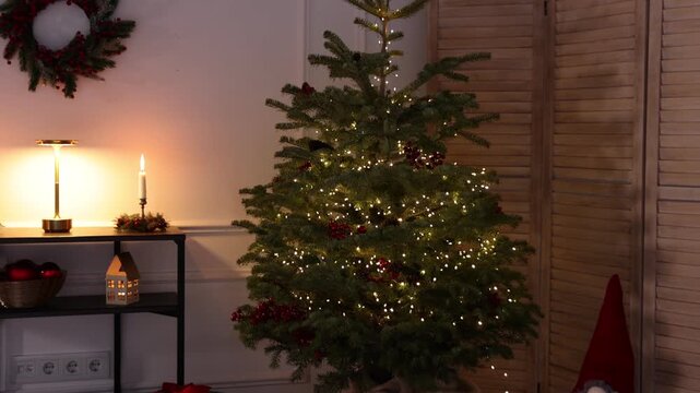 Beautiful Christmas tree and other festive decor indoors. Camera moving forward and down