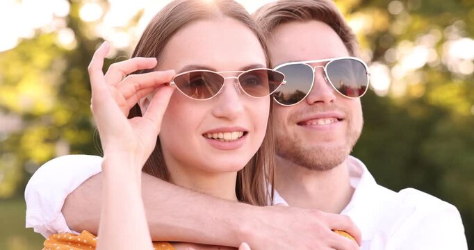 Lovely couple in sunglasses outdoors on sunny day, camera moving in