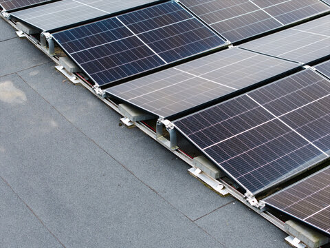 Aerial view of solar panels installed on a flat roof with mounting hardware in Malpils, Sigulda Municipality, Latvia.