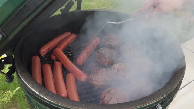 hot dogs and hamburgers cooking on the grill