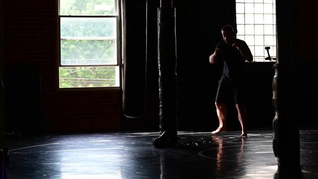 Boxing martial arts gym in silhouette man shadow boxing practicing, boxing bag, practicing martial arts, perfect copy space background image, kickboxing fight sport wellness 