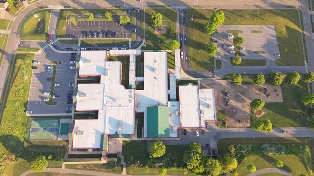 Aerial perspective of a substantial educational building in Johnson City, Tennessee, highlighting the extensive parking area, manicured lawns, and nearby roadways under bright, clear skies