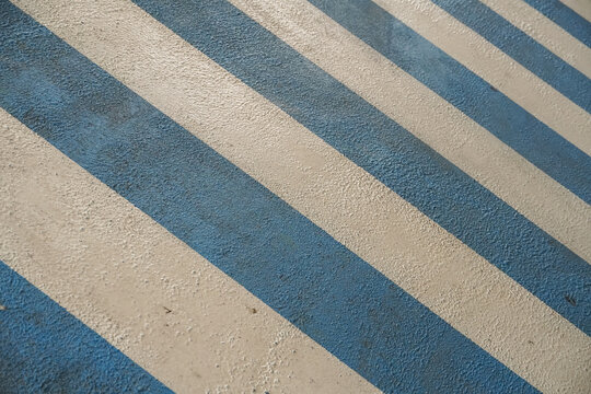 Diagonal blue and white stripes on a textured surface