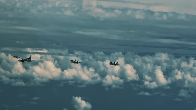 Two fighter jet aircraft flying behind military bomber in 4K Ultra HD footage
