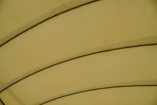 Abstract pattern of curved lines and textured surfaces in pale yellow tones