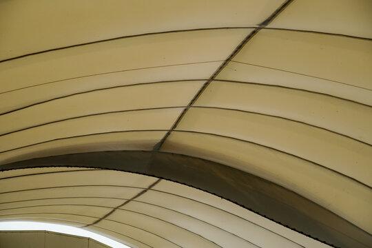 Curved fabric canopy structure with intersecting lines and shadows